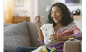 Woman enjoying a snack in flexible packaging