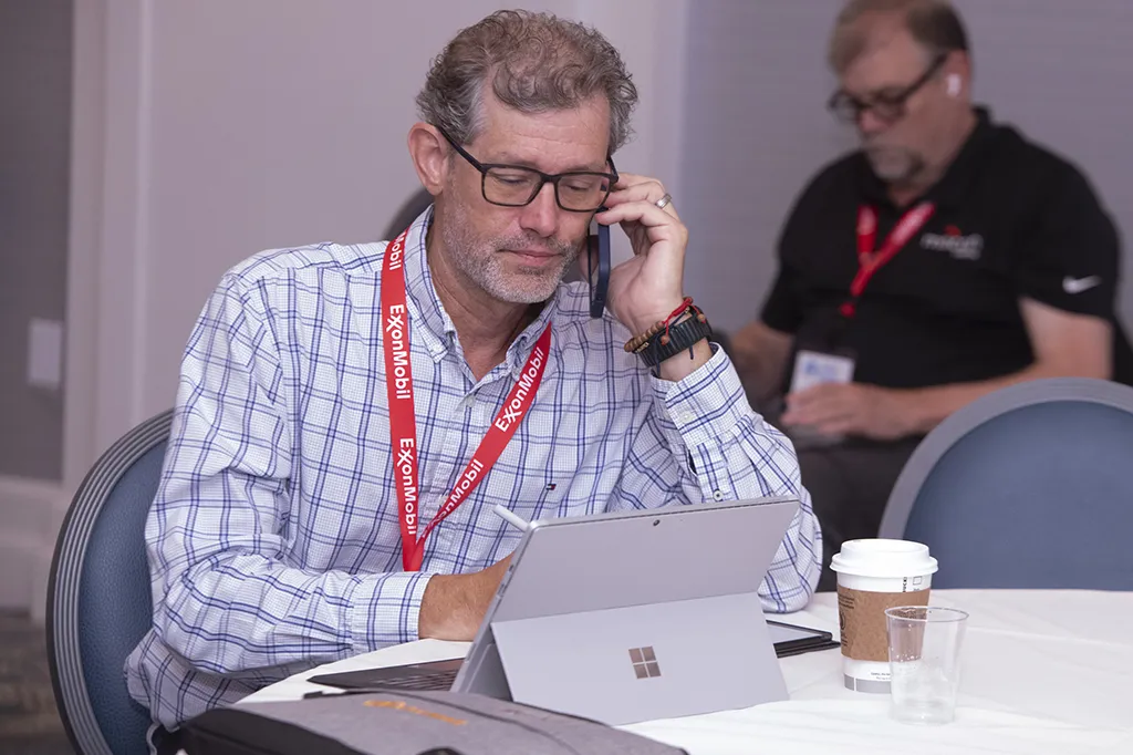 A man using wifi on his phone and laptop at Global Pouch Forum