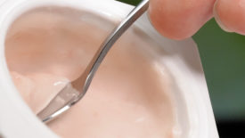 Spoon in cup stirring yogurt