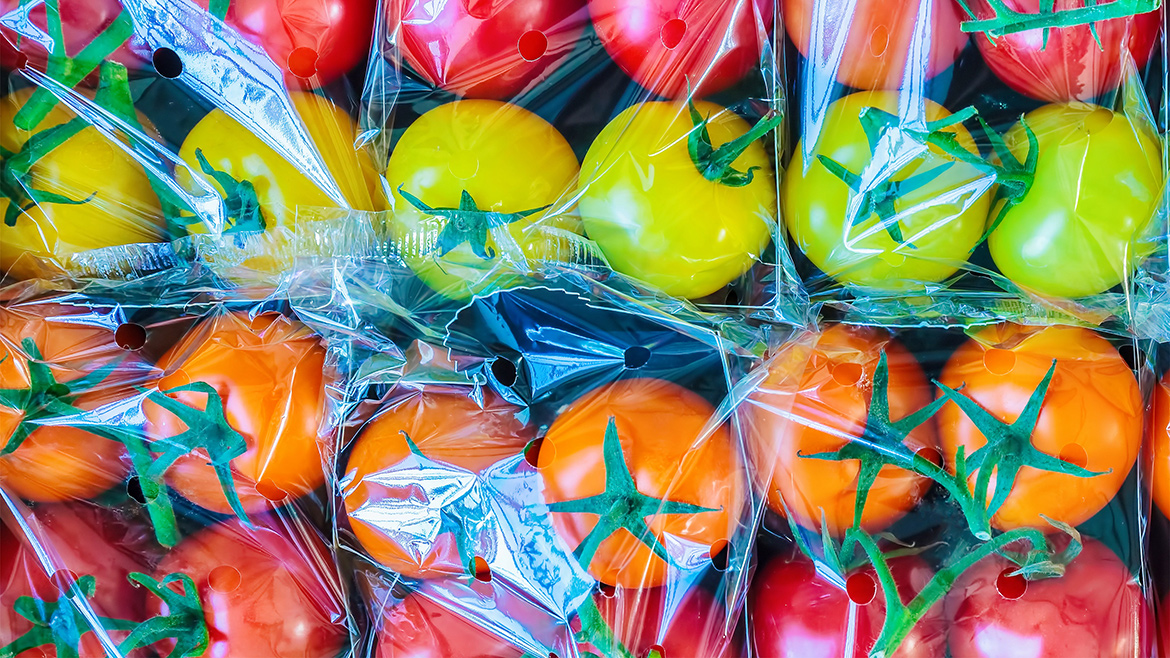 Retail display with fresh plastic wrapped cherry tomatoes.